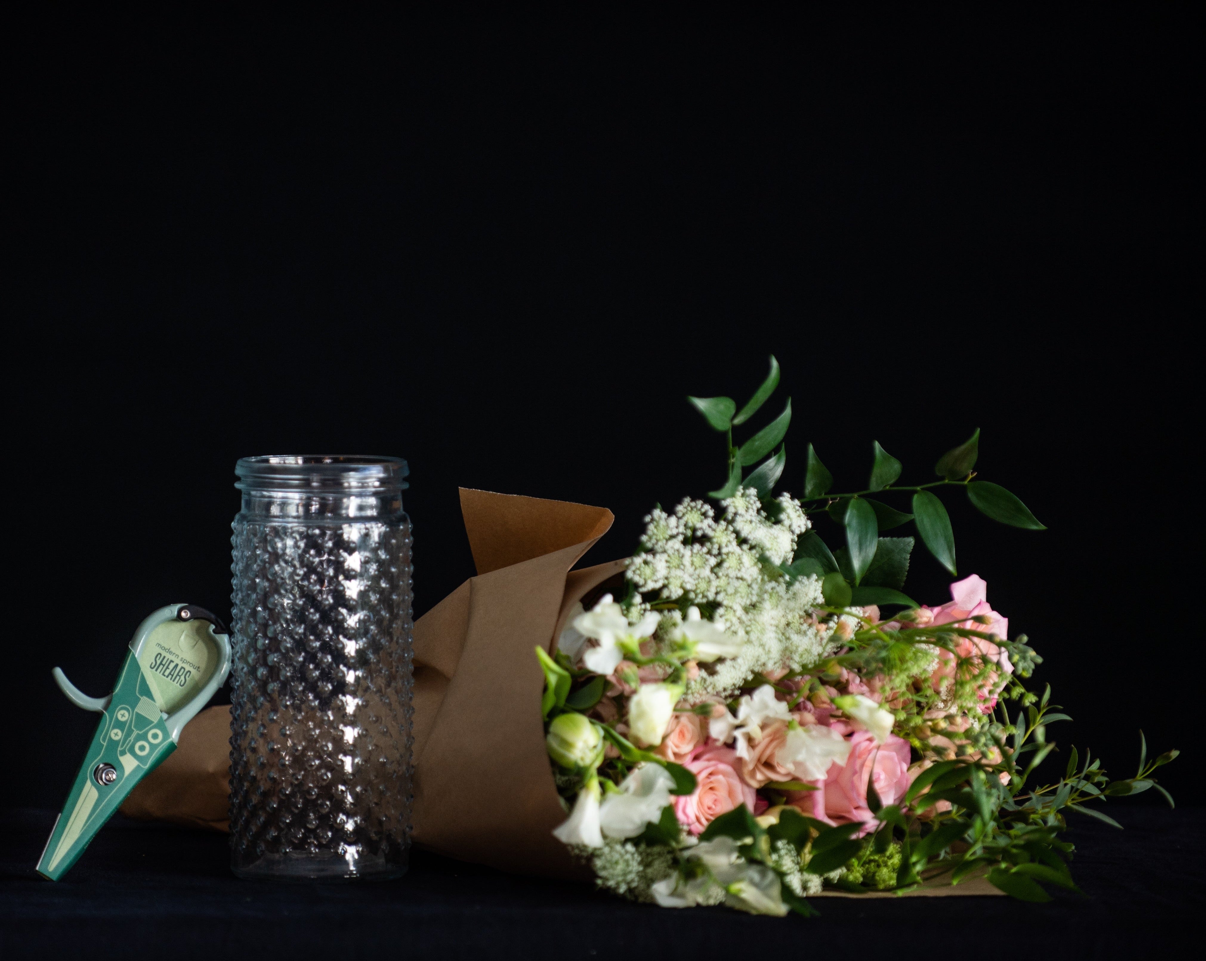 A DIY flower arranging kit with fresh flowers, floral shears, and a vase
