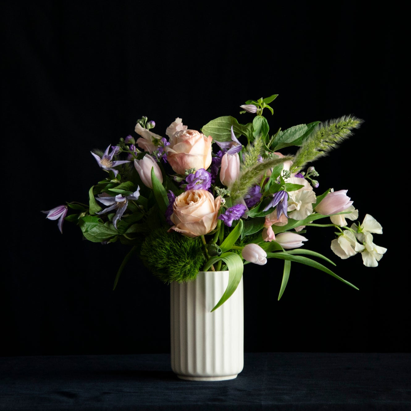 spring floral design of garden roses, tulips, and seasonal accents