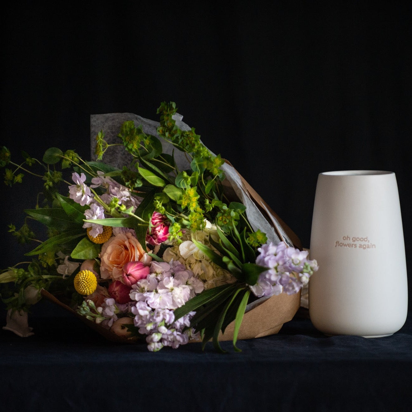 A wrap of flowers and vase that says "o good, flowers again"
