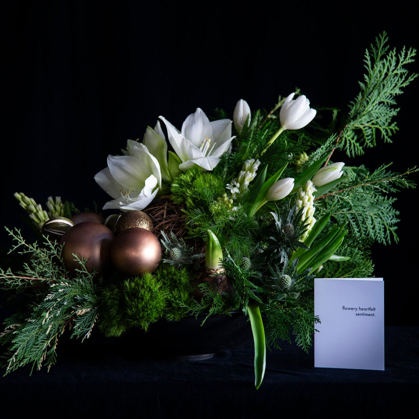 winter holiday floral design of winter white stems oversized with festive ornaments