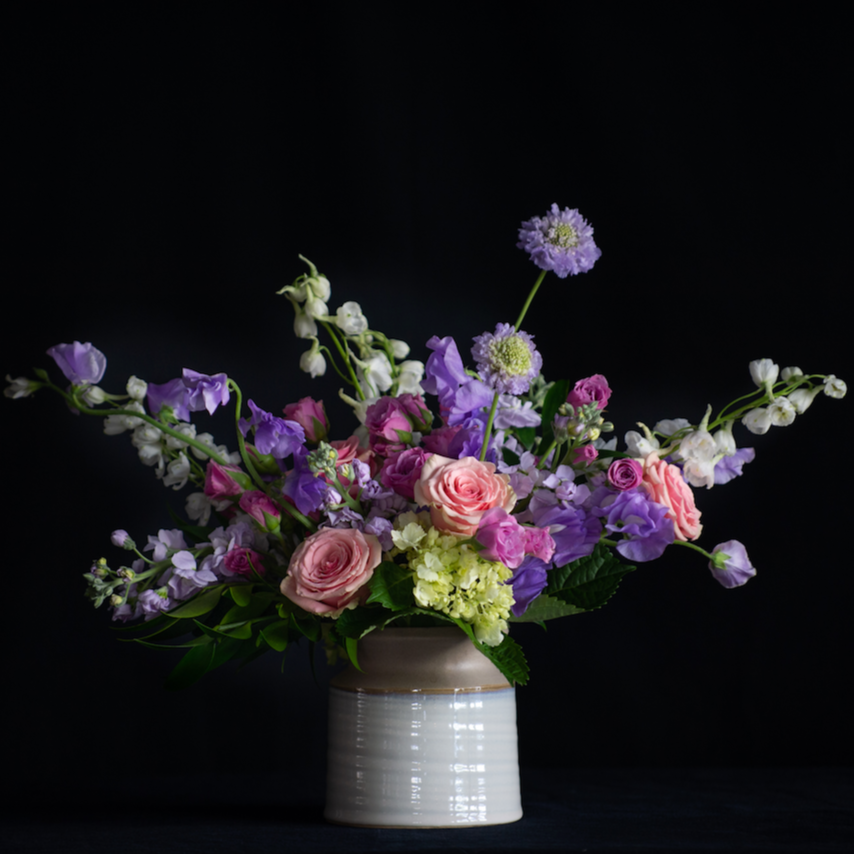 Luxury Spring Floral design of novelty pink and lavender stems in a ceramic vessel. Made by a local florist.