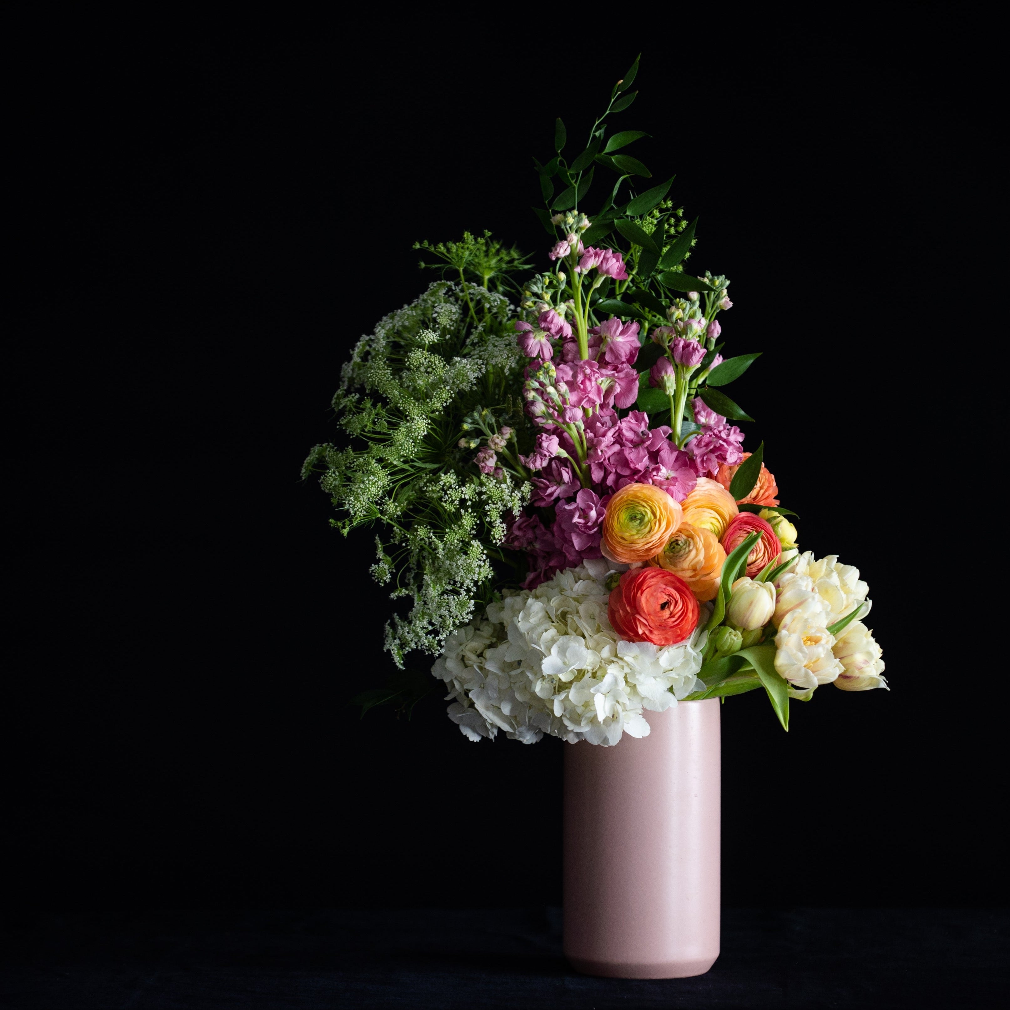 Mother's Day flowers in a pink vase with pastel hydrangea, ranunculus, tulips, and stock. 