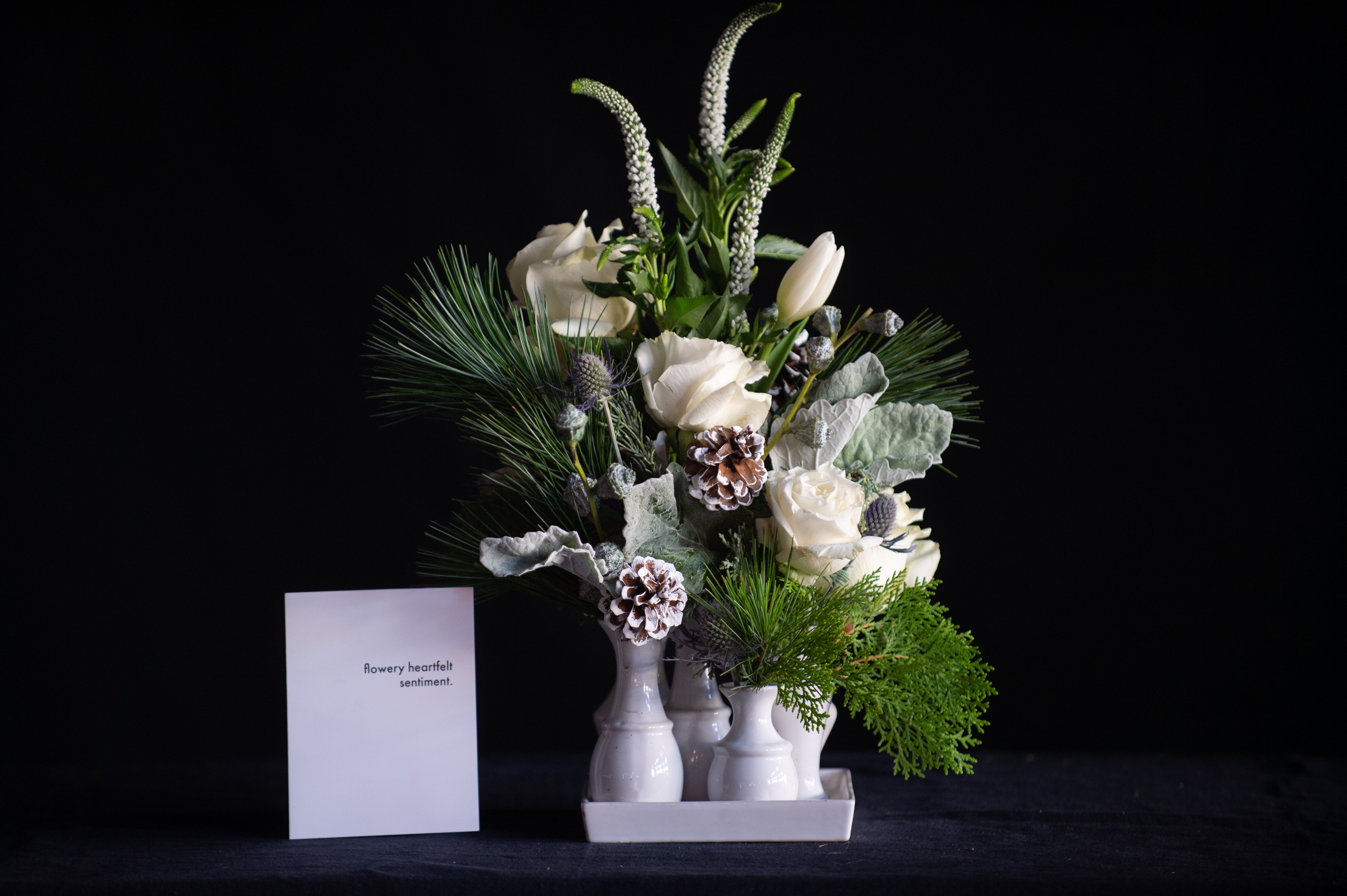 A multi bud vase filled with wintery stems