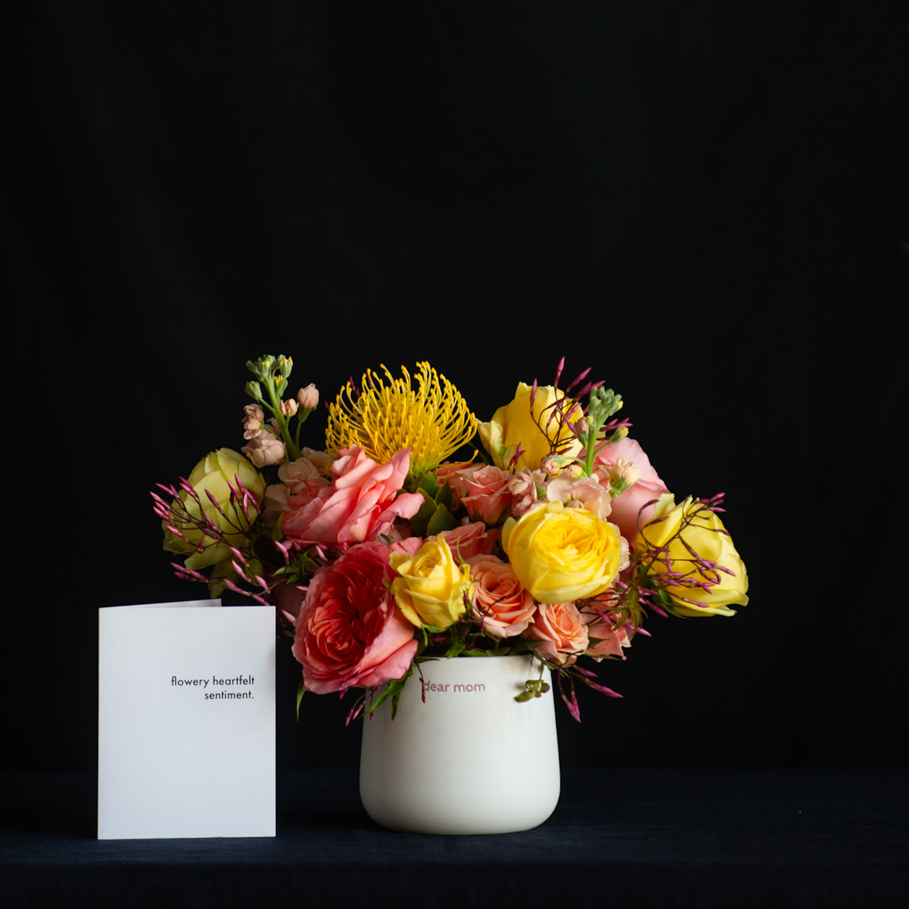 A yellow and pink floral design in a vase that says "dear mom good job I turned out perfectly"