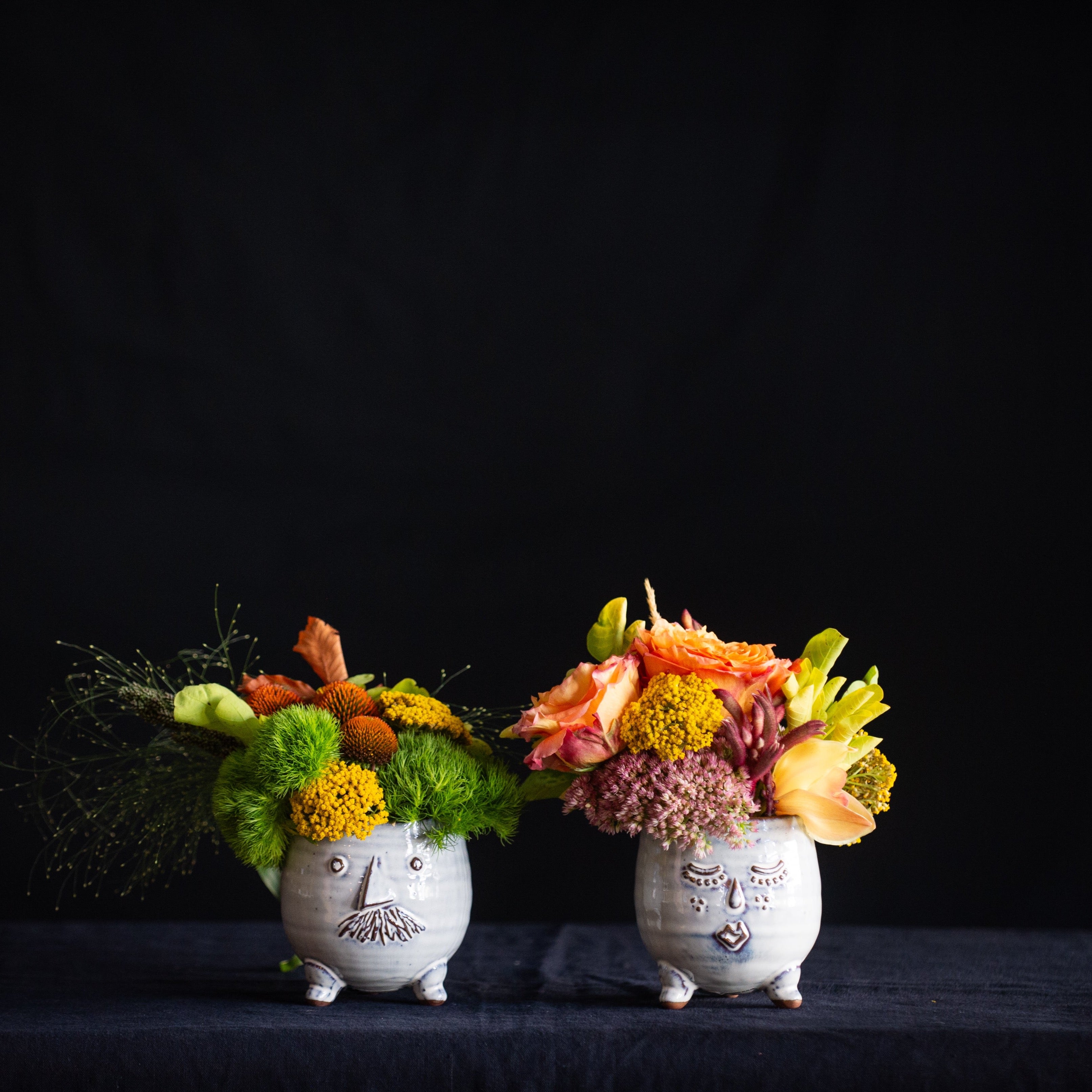 Mr. and Mr. pots filled with greenery and seasonal stems.