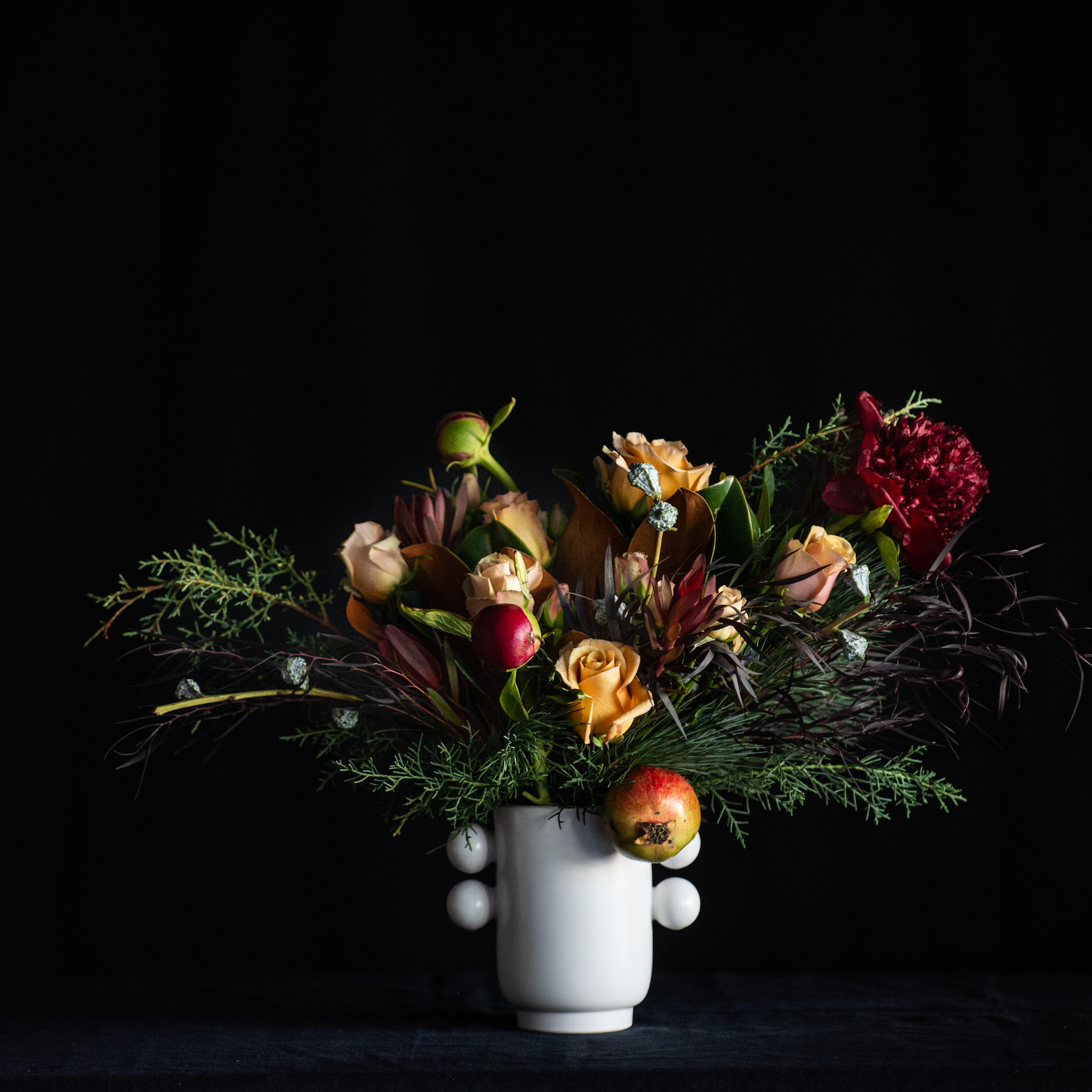 Peony upgrade to flower design with roses, holiday greens and pomegranate