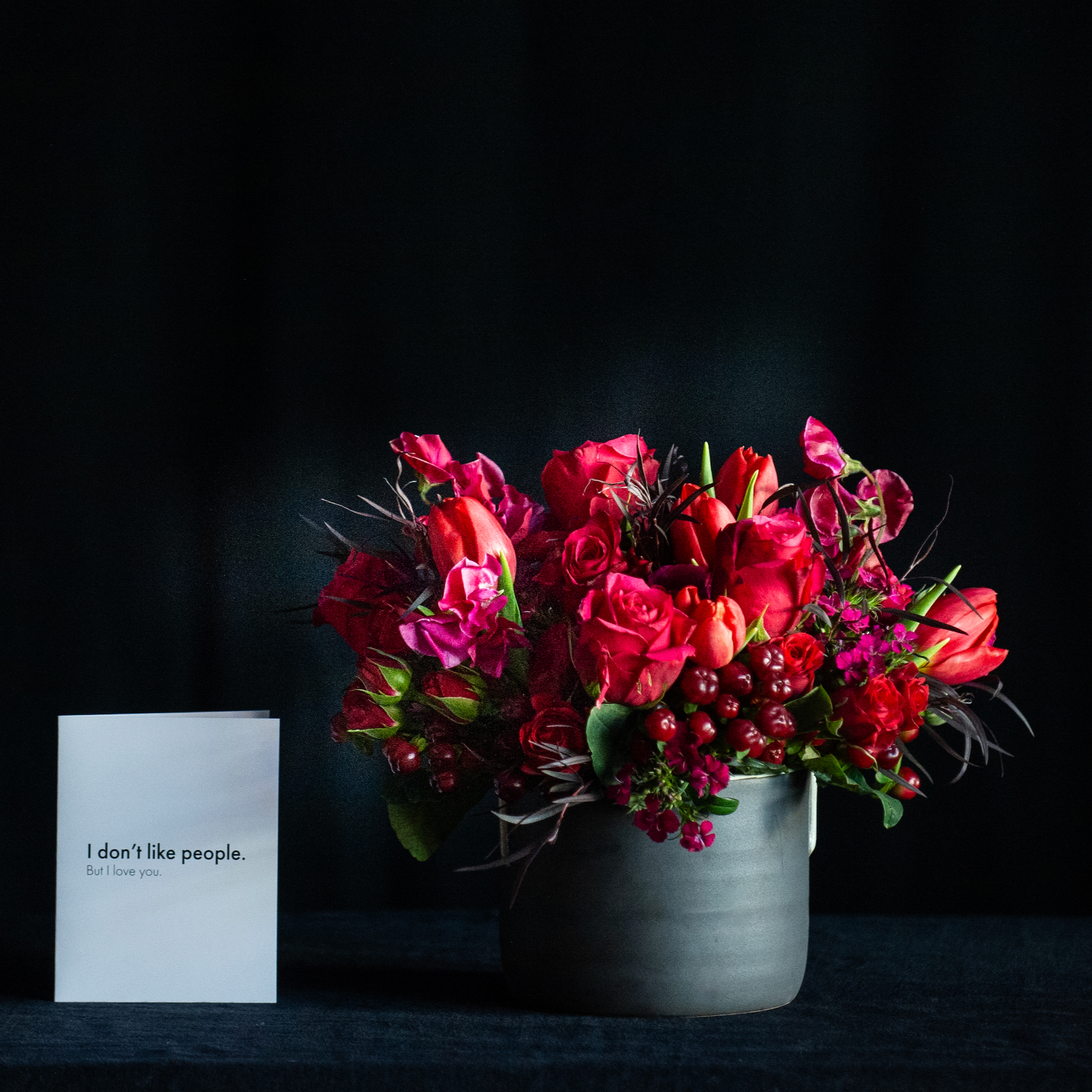 Lush floral design of red roses in black matte container
