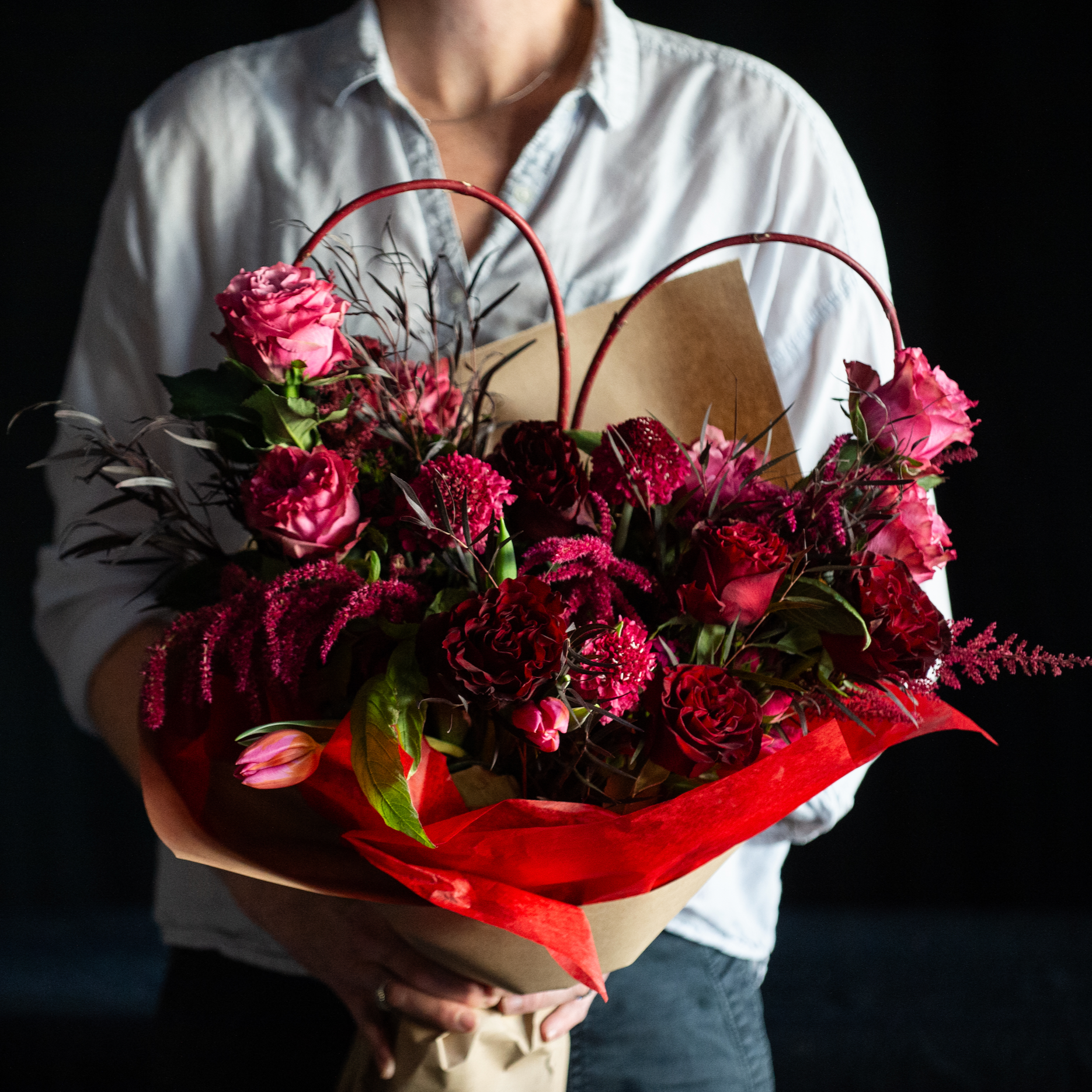 A bouquet of red and magenta roses for valentines day with red branch heart