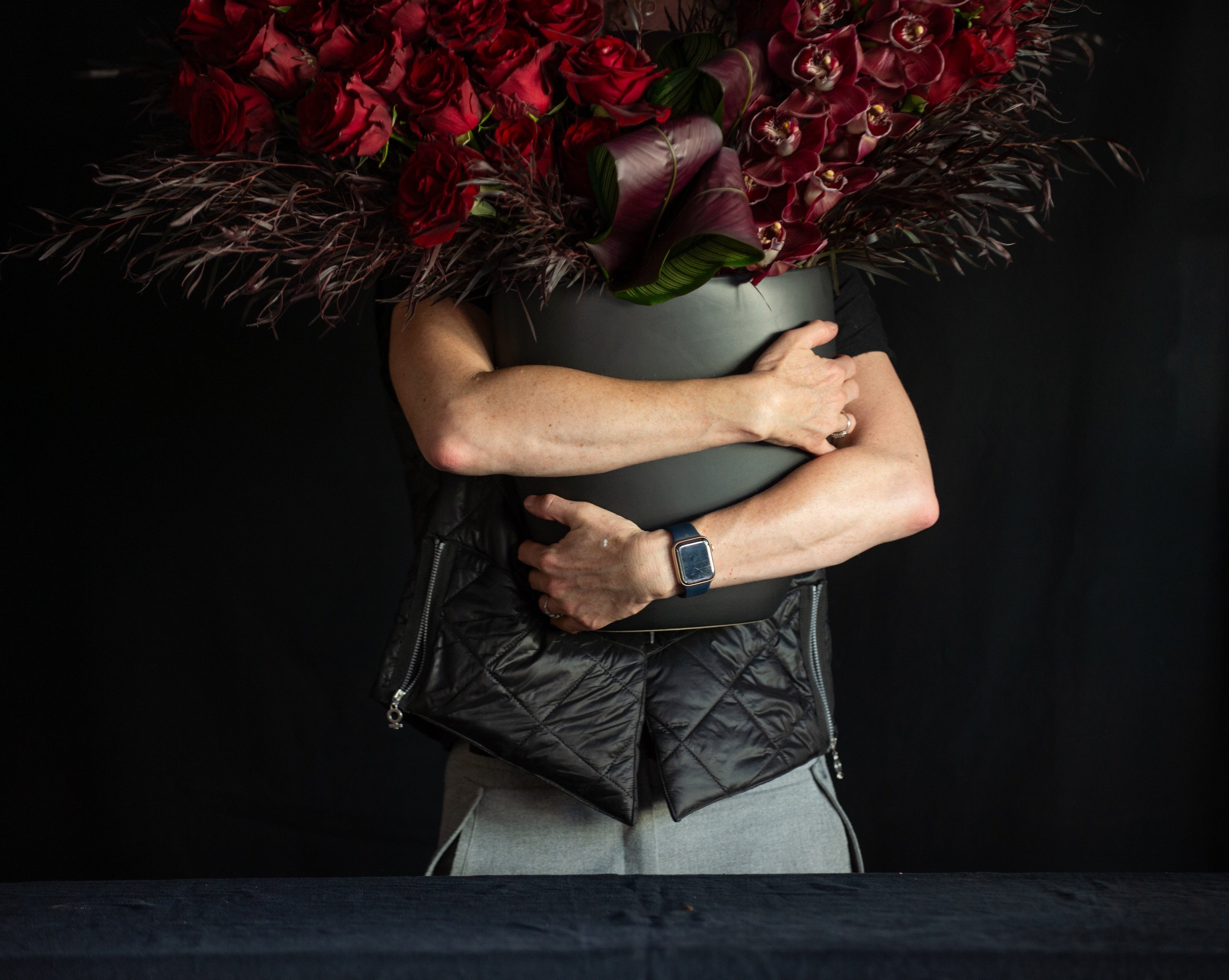 3 dozen red roses with orchids in a black vase for valentines day