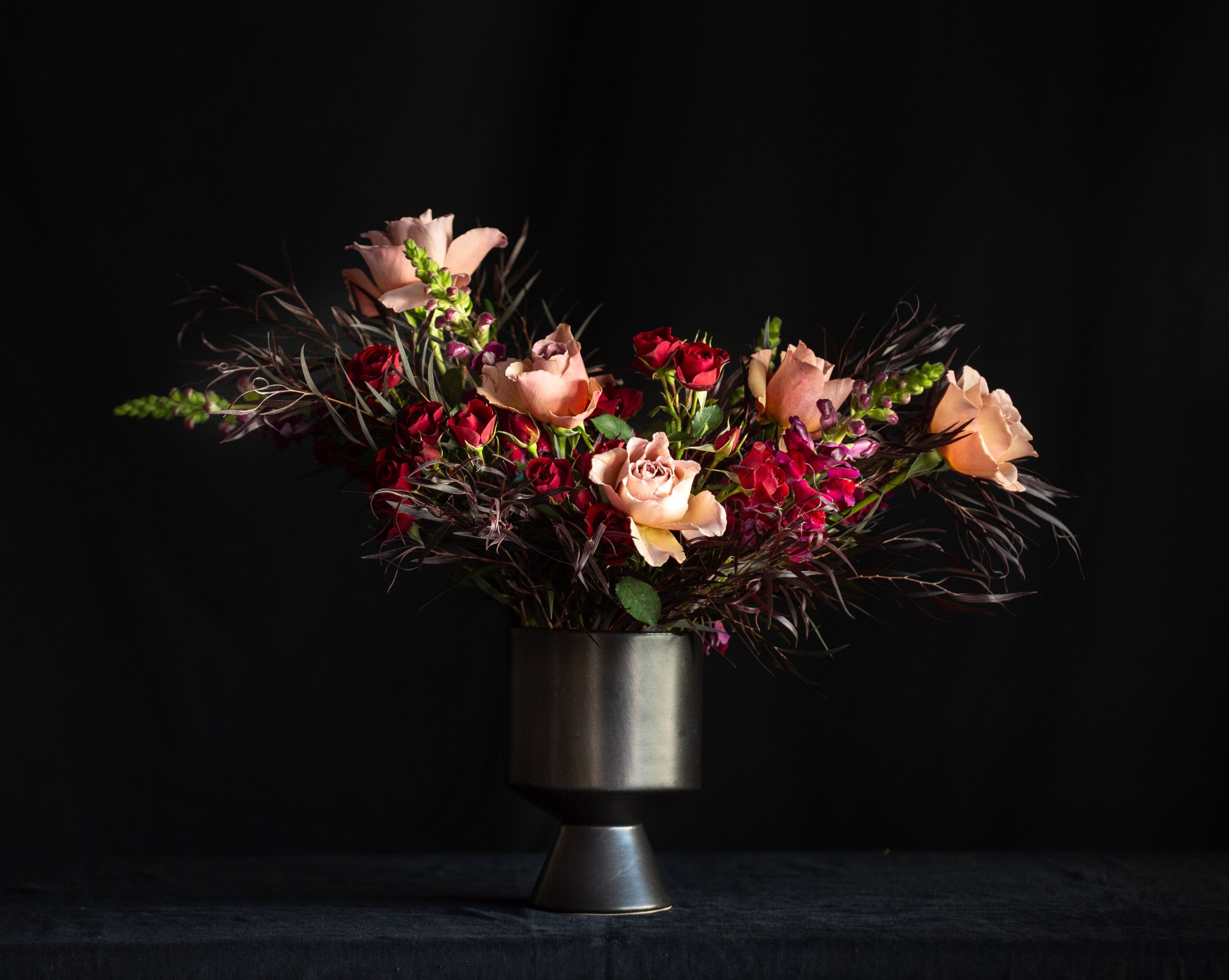Garden roses, spray roses, and snap dragons for Valentines day in a black vae