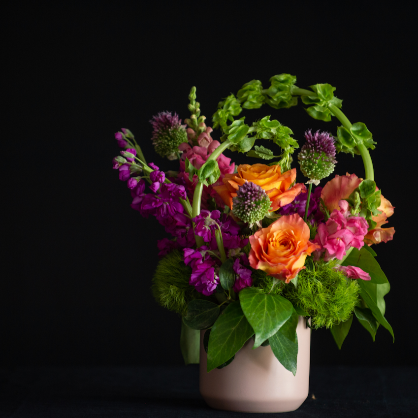 bright orange and magenta flowers in a matte pink container