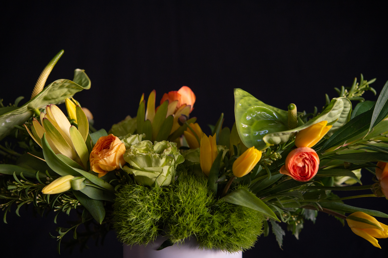 Details of floral design of green anthurium, green roses, tulips, ranunculus, and premium greenery
