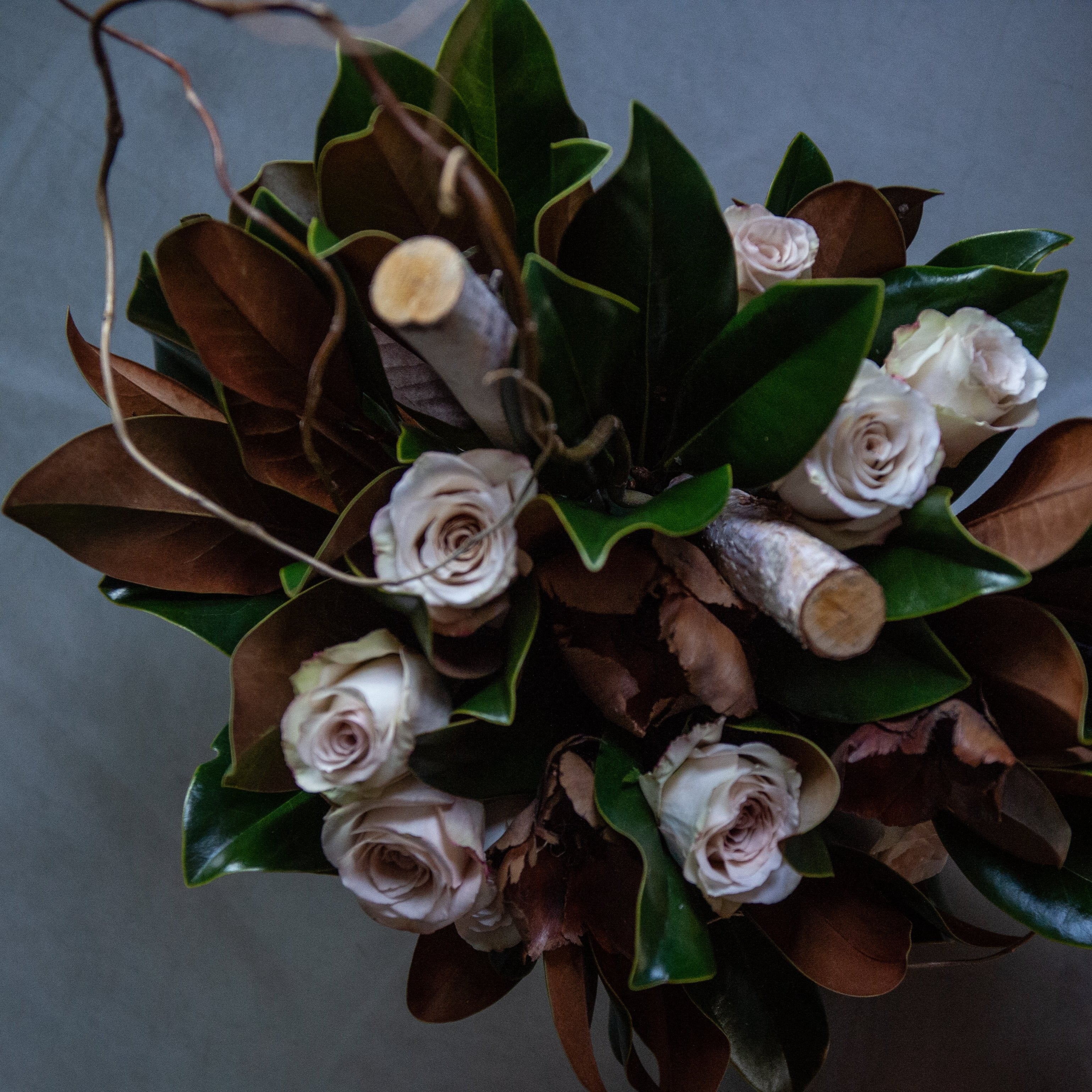 Luxury floral design of taupe roses with curly willow, magnolia, birch branches, preserved florals created by a local florist