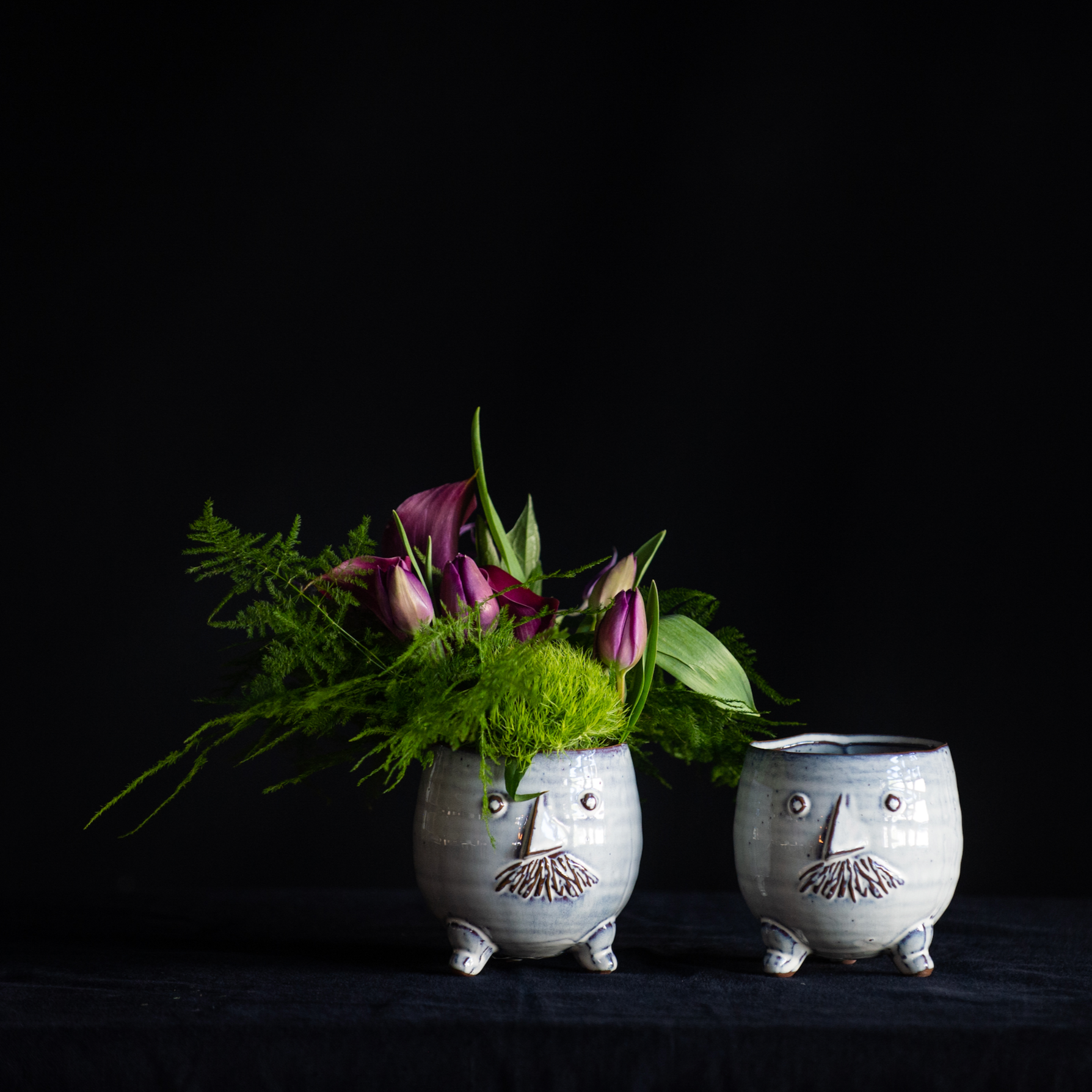 Mr. and Mr. pots filled with greenery and seasonal stems.