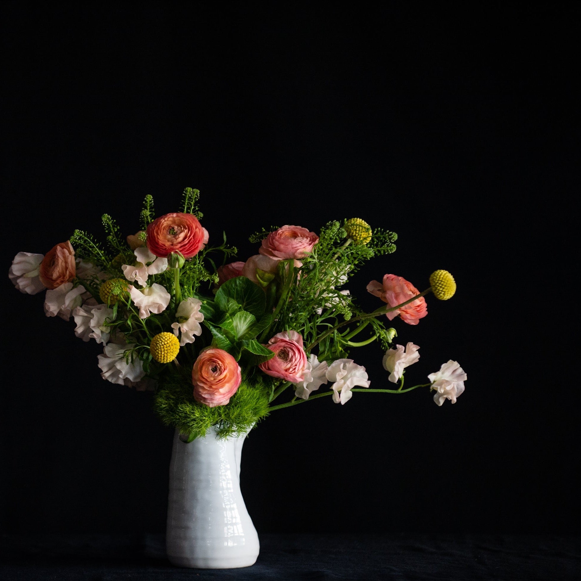 This design is filled with a dozen ranunculus (peach or yellow), sweet peas, and super fun craspedia. It's literally sunshine and happiness in flower form! 