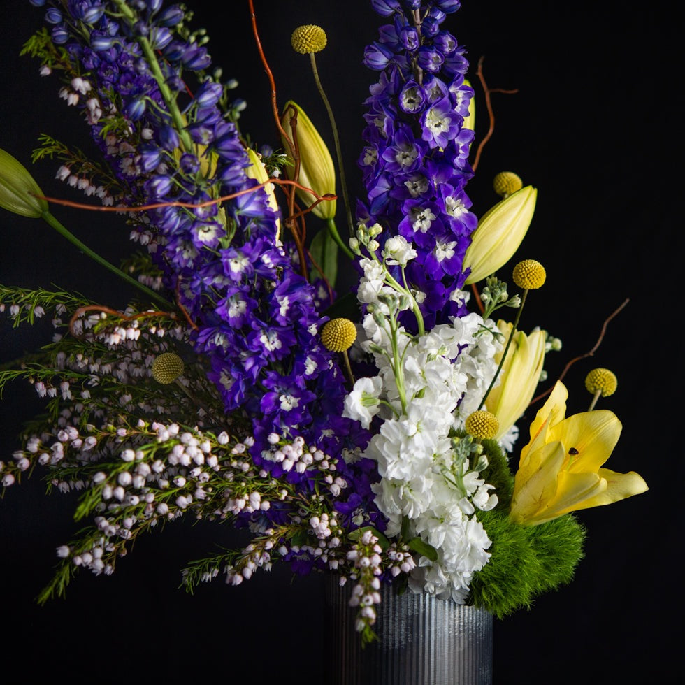 Vertical design of delphinium, lilies, stock, and seasonal blooms