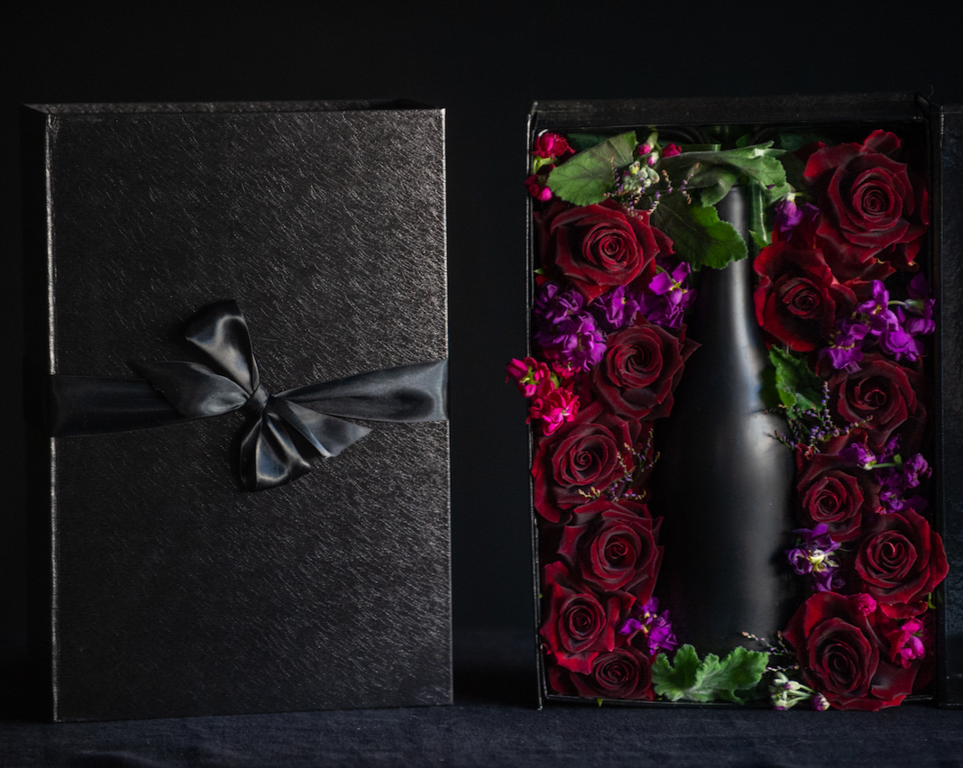 The perfect way to package your gift. A box tightly filled with a dozen roses to surround your favorite bottle. 