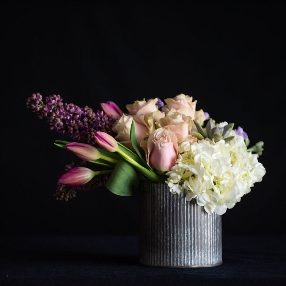 Hydrangea, roses, lilac, tulips and a succulent in a zinc container