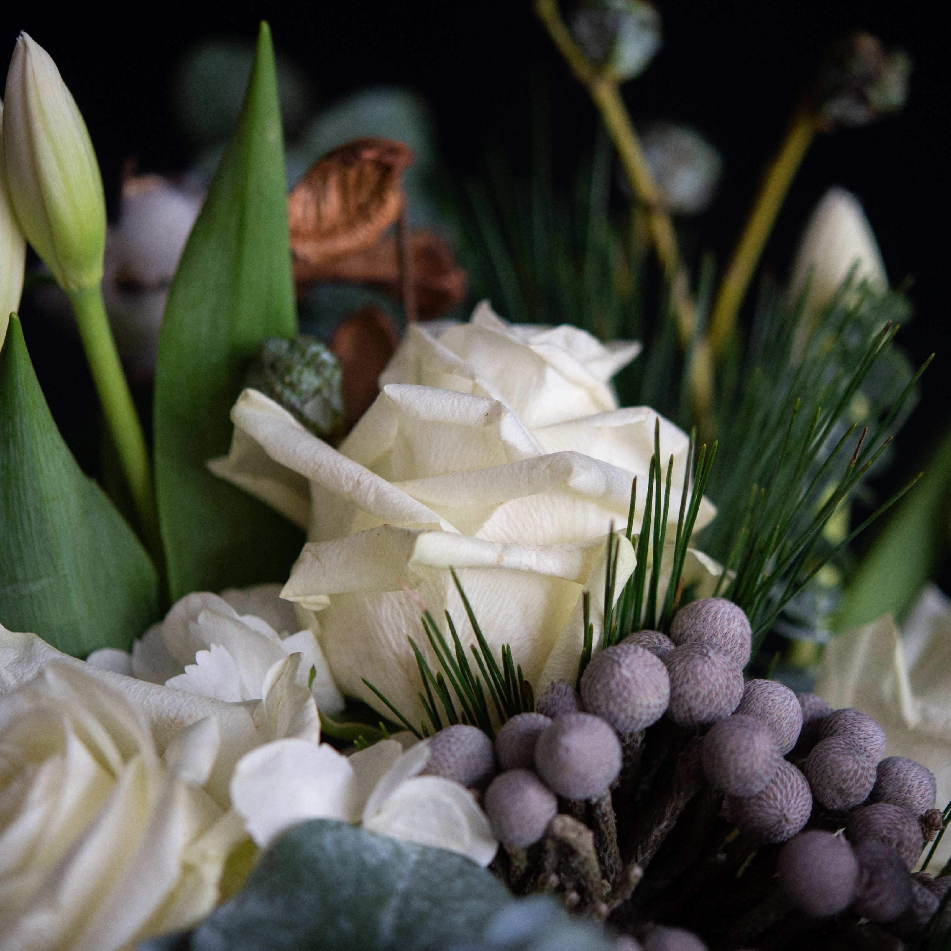  Holiday greens, magnolia leaves, brunia berries, silver bells, and eucalyptus perfectly compliment the creamy winter whites of tulips, roses, hydrangea, and even cotton bolls