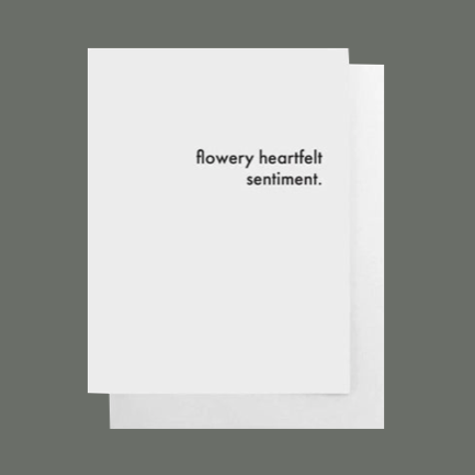 White greeting card with black text that says "flowery heartfelt sentiment" blank inside